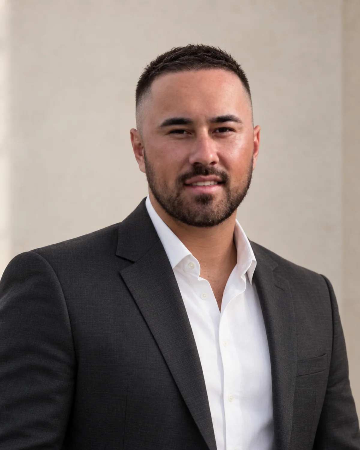 Makea Tangaroa, Director of Monicrest, wearing a charcoal jacket and white shirt.