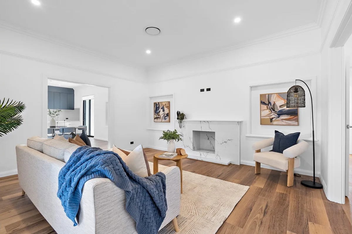 Residential living room with timber flooring, a fireplace and natural light.
